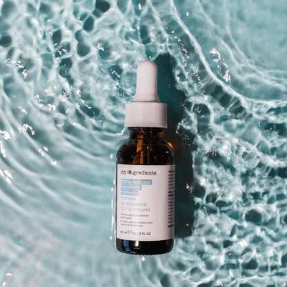 Amber glass bottle of my iN.gredients 100% Natural Squalane Formula 30ml with white dropper and turquoise label on rippling water background, highlighting a lightweight vegan oil that seals in moisture and soothes dry, red skin.