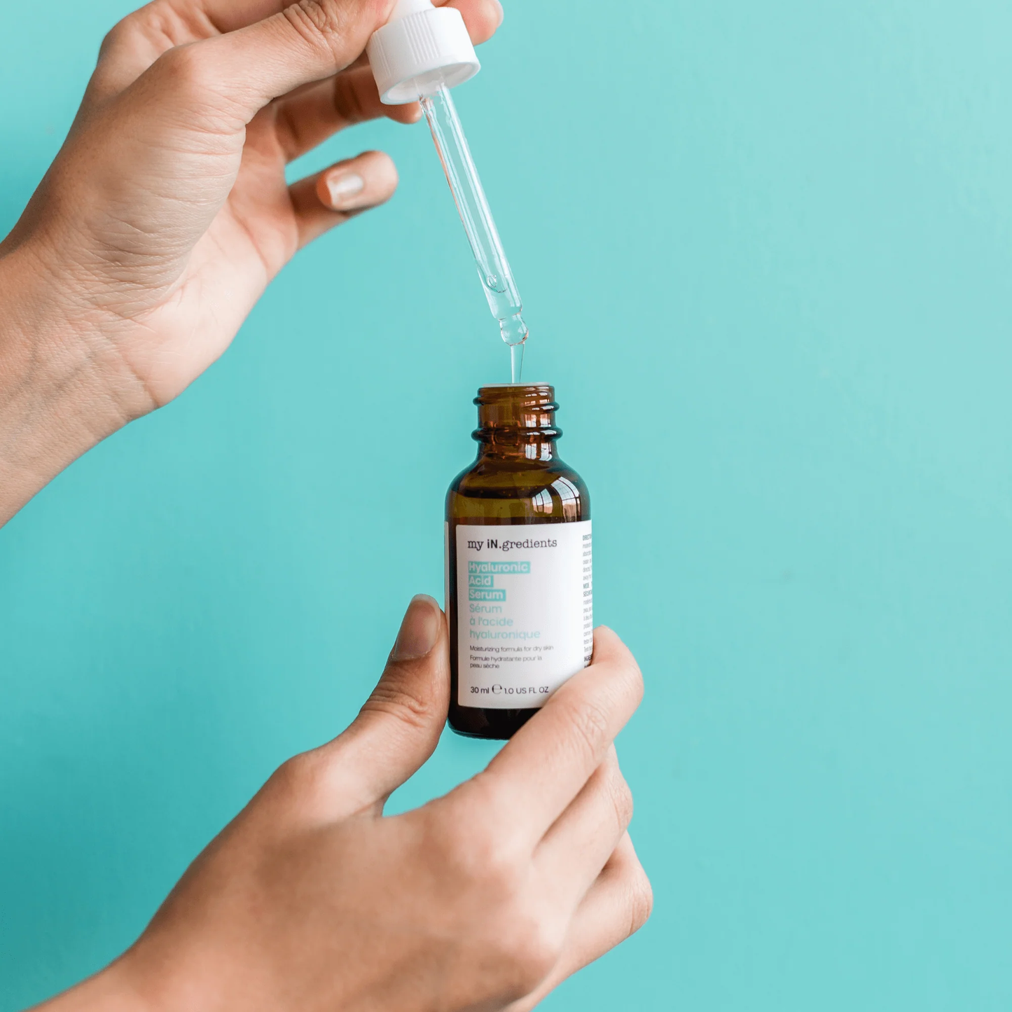Amber glass bottle of my iN.gredients Hyaluronic Acid Serum 30ml with white dropper and turquoise label, next to its box, showcasing a 2% hyaluronic acid hydrating serum for very dry, tight, dehydrated facial skin.